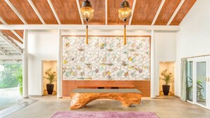 A modern interior with a wooden bench, a decorative wall, and two potted plants. - Aurika, Coorg - Luxury by Lemon Tree Hotels (Madikeri)