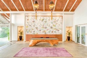 Ein modernes Interieur mit einer Holzbank, einer Wandverkleidung und zwei Zimmerpflanzen.