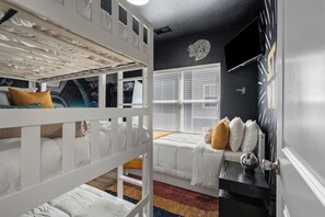 A child's bunk bed room with a starry ceiling, a window with blinds, and a wall-mounted TV. - Walk-In 3BR | Fun Bunk Room + Arcade | Sleeps 9 (Branson)