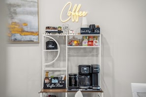 Eine Kaffeestation mit Kaffeemaschine, Kaffeemühle und einer Kaffeetasse.