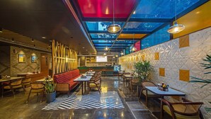 A modern interior with a bar area, seating, and a patterned floor. - Inde Signature Jaipur (Jaipur)