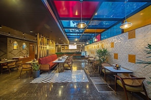A modern interior with a bar area, seating, and a patterned floor. - Inde Signature Jaipur (Jaipur)