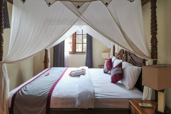 A neatly made bed with white and pink bedding, a canopy, and a bedside table with a lamp. - Ubud Asri by Zuzu (Ubud)