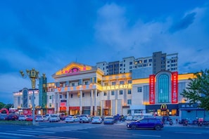 A multi-story building with commercial establishments on the ground floor, including a McDonald's. - Vienna Hotel (Changping)