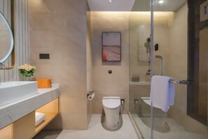A modern bathroom with a glass shower enclosure, a white toilet, and a sink with a mirror above it. - Vienna International Hotel (Nantong)