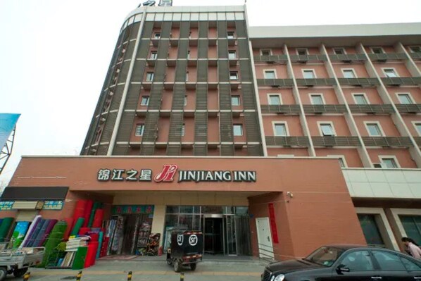 A multi-story building with a prominent signage for 'JINJIANG INN' at the ground level. - Jinjiang Inn Xinxiang Railway Station Branch (Xinxiang)