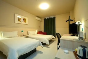 A hotel room with two beds, a desk, a television, and a window with curtains. - Jinjiang Inn Xinxiang Railway Station Branch (Xinxiang)
