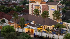A hotel with a prominent sign, multiple balconies, and a view of the surrounding neighborhood. - The Margaux Hotel Yogyakarta (Yogyakarta)