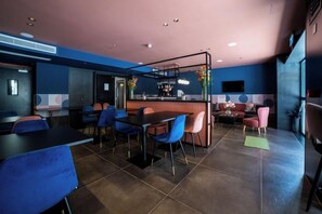 A modern interior with a bar area, seating arrangements, and a decorative partition. - Eleven Apartments (Sliema)