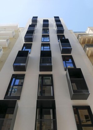Un edificio moderno con varios balcones y amplias ventanas.