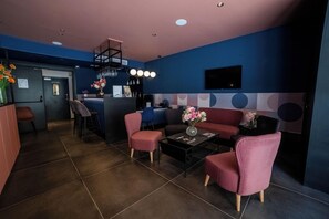A modern lobby with a reception desk, seating area, and a bar. - Eleven Apartments (Sliema)