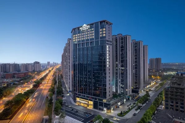 A high-rise hotel with a modern glass facade, multiple floors, and a prominent signage. - Microtel by Wyndham Changsha Xingsha (Changsha)