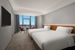 A hotel room with two beds, a flat-screen TV, a small table with a chair, and a view of the city. - Microtel by Wyndham Changsha Xingsha (Changsha)