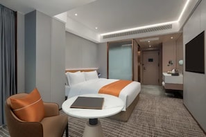 A hotel room with a bed, a chair, a table, and a bathroom. - Microtel by Wyndham Changsha Xingsha (Changsha)