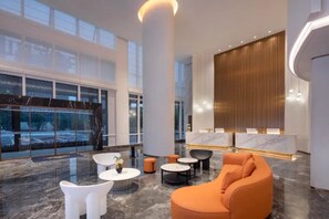 A modern lobby with a reception desk, seating area, and large windows. - Microtel by Wyndham Changsha Xingsha (Changsha)
