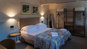 Een hotelkamer met een bed, nachtkastjes, een spiegel en een stapelbed.