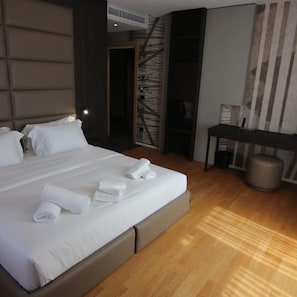 Una habitación de hotel moderna con una cama grande, un escritorio y vistas a un edificio.