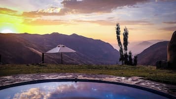 Una piscina con vista a las montañas durante el atardecer.