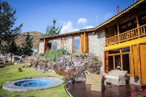 A stone house with a wooden balcony, a swimming pool, and outdoor furniture. - Refugio Vinak (Vinac)