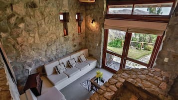 Una habitación de paredes de piedra con un sofá y una chimenea de piedra.