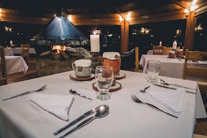 A table set for dining with a stone fireplace in the background.