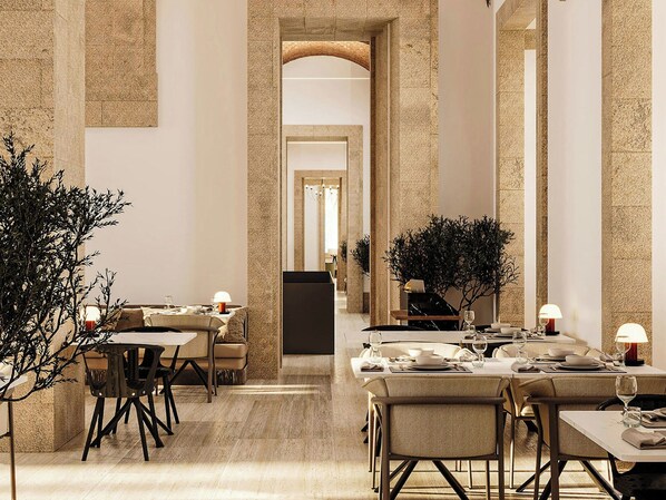 A spacious hotel dining area with high ceilings and a modern design, featuring multiple dining tables and chairs.