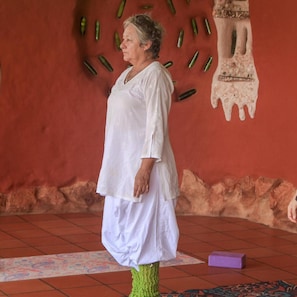 A person standing in a room with a red wall and a mural. - Casa Encuentro Ecolodge (Guatapé)