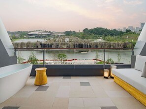 Una terraza en la azotea con vistas a una cascada, zona de estar y un edificio moderno al fondo.