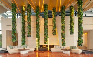 A modern lobby with vertical gardens, seating areas, and a reflective floor. - Chengdu Expo Waterfall Hotel - Mgallery Collection (Chengdu)