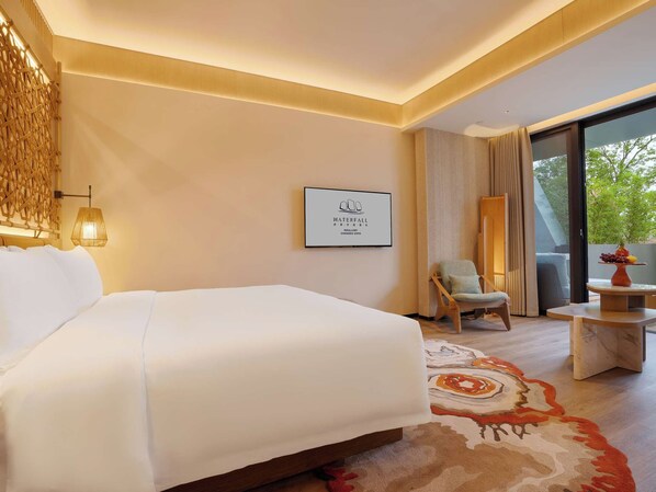 A hotel room with a large bed, a chair, a small table, and a view of the outdoors. - Chengdu Expo Waterfall Hotel - Mgallery Collection (Chengdu)
