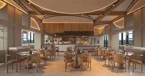 A spacious restaurant with multiple dining tables and chairs, a central kitchen area, and large windows providing natural light. - Chengdu Expo Waterfall Hotel - Mgallery Collection (Chengdu)