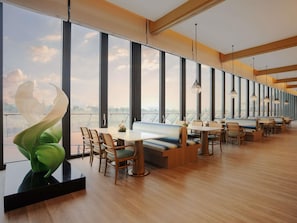 A modern dining area with high ceilings, large windows, and a view of the cityscape. - Chengdu Expo Waterfall Hotel - Mgallery Collection (Chengdu)