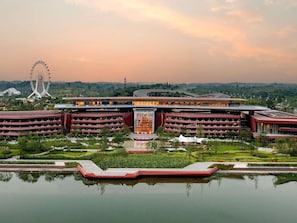 A hotel with multiple floors, a central courtyard, and a Ferris wheel in the background. - Chengdu Expo Waterfall Hotel - Mgallery Collection (Chengdu)