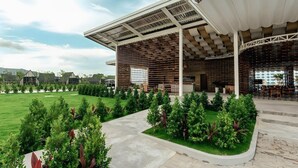 A modern building with a covered outdoor seating area, surrounded by well-maintained greenery and a clear sky. - Summer Bay Beach Club and Cabins Sihanoukville by Preference (Prey Nob)