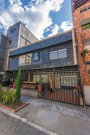 Un edificio con fachada de piedra, una reja de metal y un cartel que dice 'LARES DELA'.
