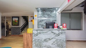 En receptionsdisk med en marmorskiva, en dator och en brandsläckare.