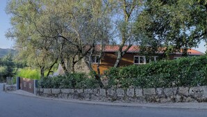 A residential building with a stone wall, a red-tiled roof, and a tree in front. - Quinta da Teimosa by Portugal Active (Viana do Castelo)