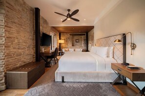 A hotel room with a bed, a desk, a chair, a television, and a ceiling fan. - Hotel La Compania In The Unbound Collection By Hyatt (Panama City)