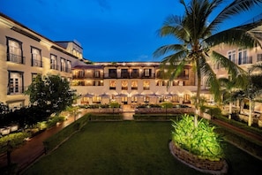 A hotel courtyard with a central lawn, surrounded by buildings with balconies and outdoor seating areas. - Hotel La Compania In The Unbound Collection By Hyatt (Panama City)