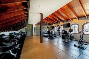 A gym with exercise equipment, wooden beams, and large windows. - Hotel La Compania In The Unbound Collection By Hyatt (Panama City)