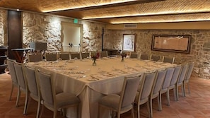 A conference room with a round table, chairs, and a stone wall backdrop. - Hotel La Compania In The Unbound Collection By Hyatt (Panama City)
