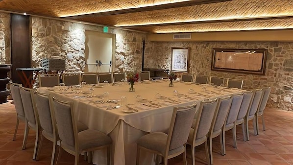 A conference room with a round table, chairs, and a stone wall backdrop. - Hotel La Compania In The Unbound Collection By Hyatt (Panama City)