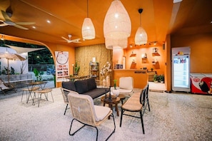 A reception area with a sofa, chairs, a table, and a refrigerator. - Lilla Rainforest Retreats (Hulu Langat)