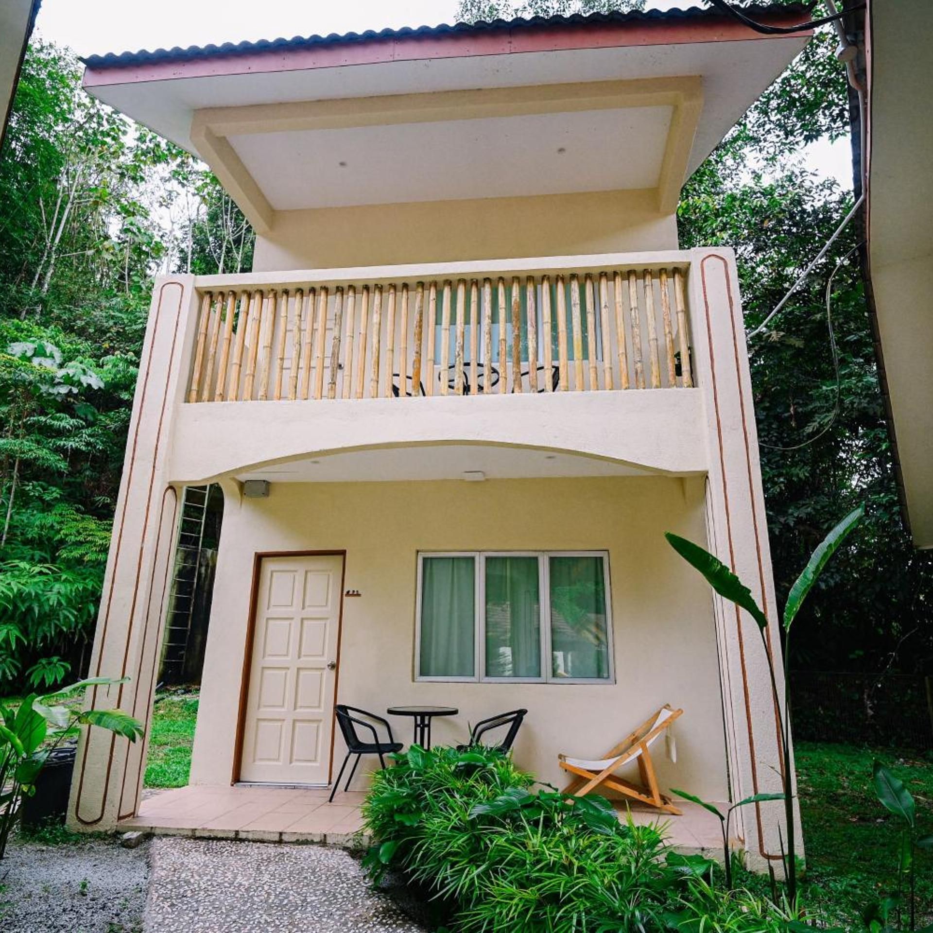 A two-story building with a balcony, a door, and a window.