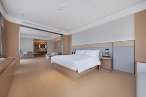 A modern hotel room with a large bed, bedside tables, a desk, and a seating area. - Ji Hotel (Wuhan)