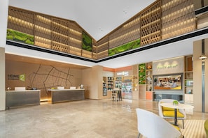 A hotel lobby with a reception desk, a seating area, and a store named 'Home MKT'. - Home2 Suites by Hilton Guangzhou Huadu (Guangzhou)