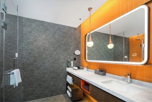 A modern bathroom with a large mirror, dual pendant lights, a shower, and a vanity with a marble countertop. - Home2 Suites by Hilton Guangzhou Huadu (Guangzhou)