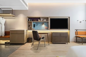 A modern, well-lit room with a desk, chair, and built-in shelving. - Home2 Suites by Hilton Guangzhou Huadu (Guangzhou)