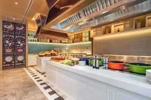 Una cocina moderna con una isla central, electrodomésticos de acero inoxidable y una variedad de utensilios y recipientes de cocina.