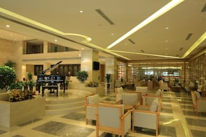Eine großzügige Lobby mit einem Flügel, gemütlicher Sitzgelegenheiten und modernem Design.